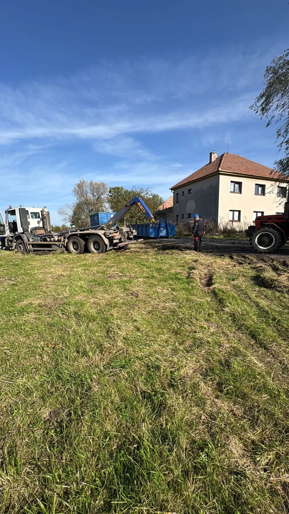 Nosič kontejnerů nakládá kontejner s odpadem