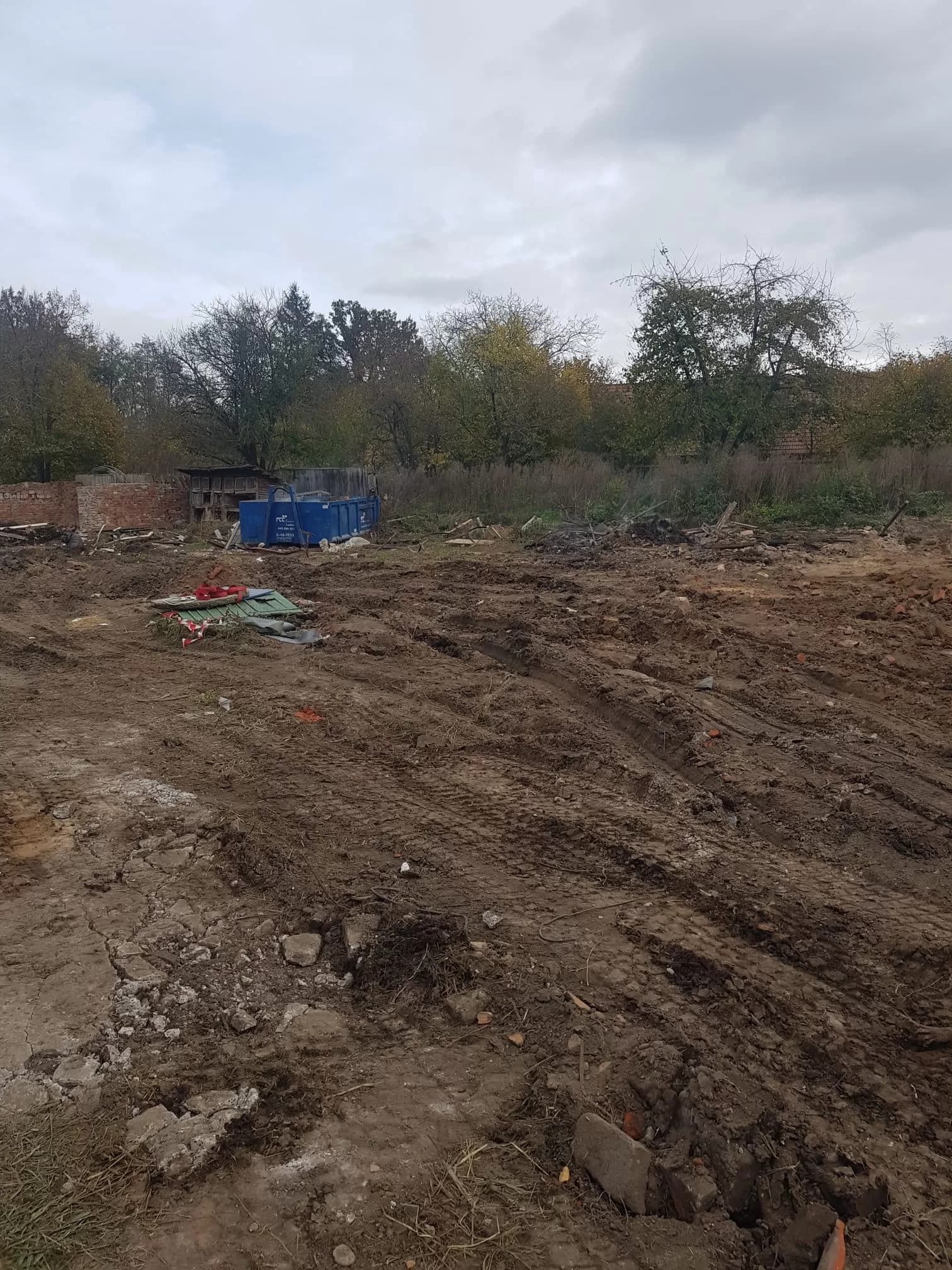 Pozemek po demolici s kontejnerem na zbylý odpad