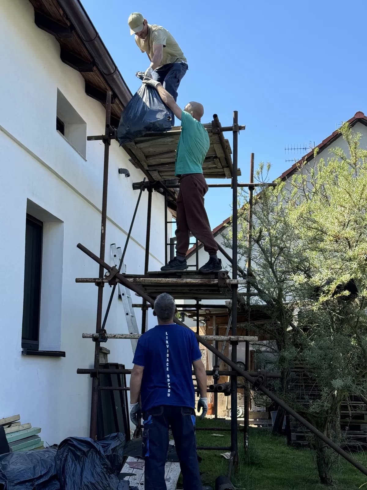 Práce na lešení u fasády rodinného domu